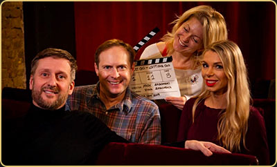 Behind the scenes with Arek Zasowski, Viola Zasowska, Paul A. Taylor & Olga Malchevska — Let Go: Letting Go Wrap Day Arek Zasowski with Viola Zasowska, Paul A. Taylor, and Olga Malchevska smiling in a red velvet cinema as they celebrate wrap day for Let Go: Letting Go, holding a clapperboard behind the scenes